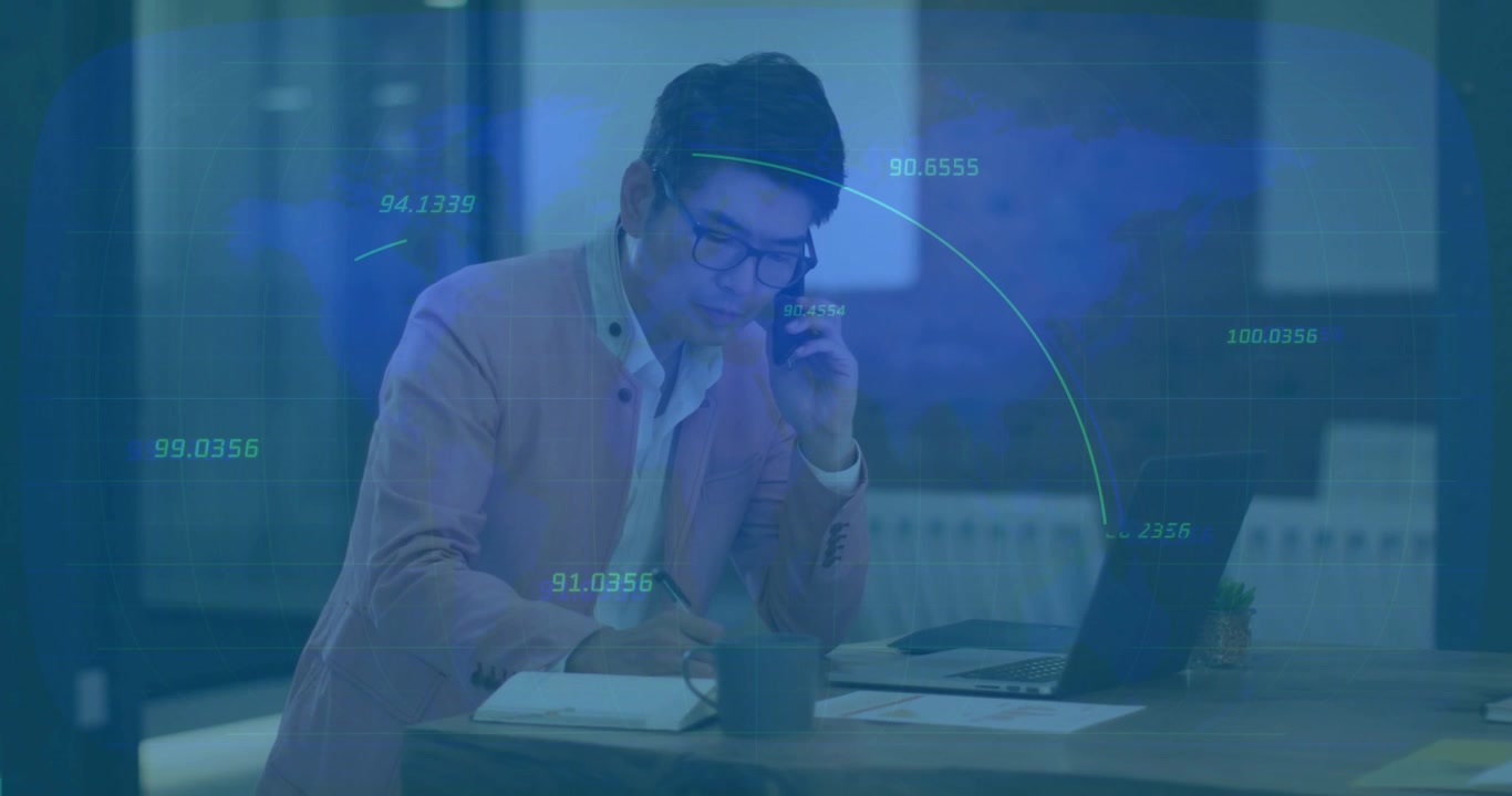 Man lifting phone and jotting notes while on business call, subtle data lines appearing over laptop
