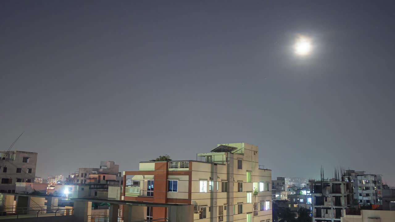 A captivating timelapse of Dhaka at night, showcasing the city's skyline as the moon slowly sets, casting a serene glow over the urban landscape.