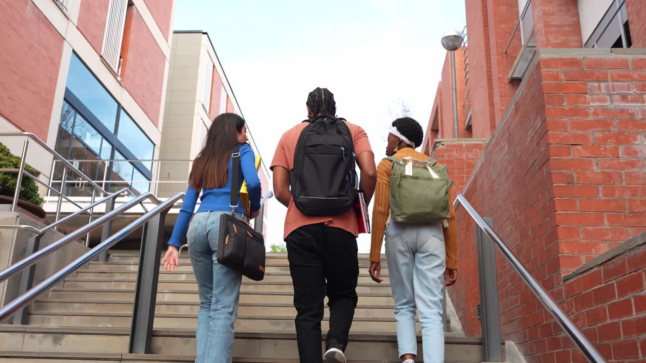 Diversos estudiantes subiendo escaleras en un campus universitario.