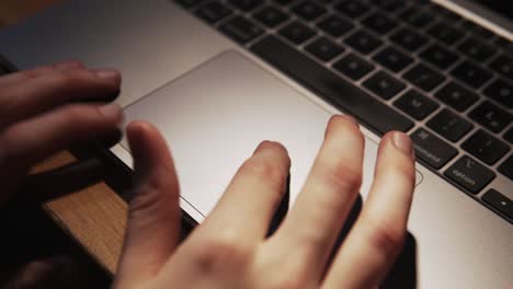 female hands scrolling on the tapboard of the laptop macbook