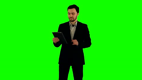 businessman using his tablet on a green screen