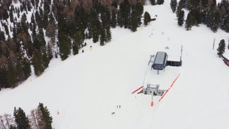 aerial flyover closed snowy alpe lusia ski area with ski lift surrounded by conifer trees in nature