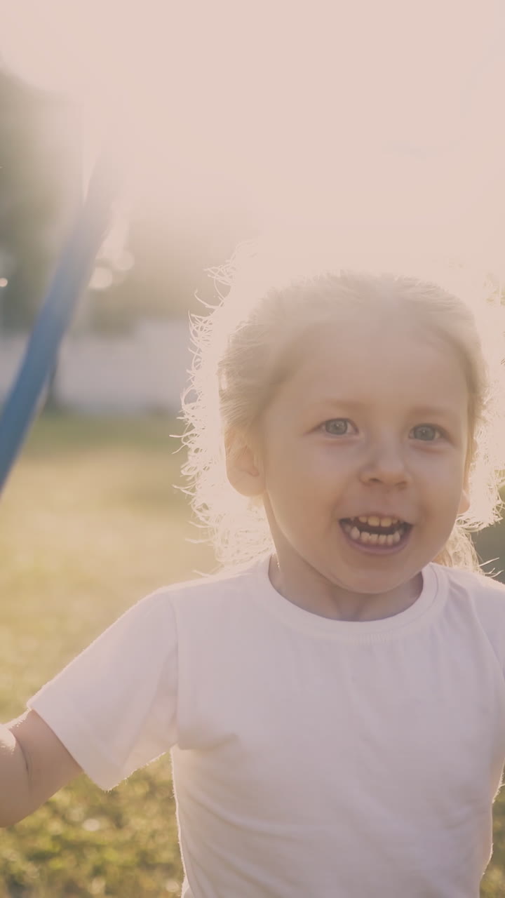 adorable blonde girl plays with butterfly net running in green sunny garden at bright back sunlight closeup