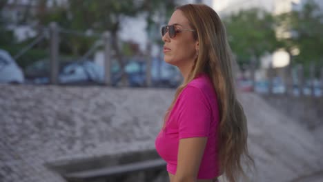 exploración urbana vibrante: vista de cerca de una chica con un elegante vestido rosa y gafas de sol explorando la ciudad