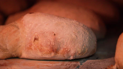 bread cooking inside a hot brick stone oven at the bakery - close up