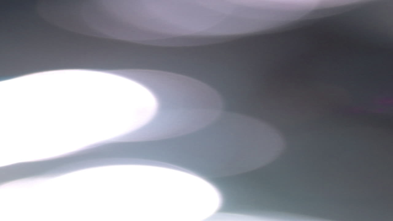 Vazamentos de Luz Bokeh Abstratos em Movimento sobre Fundo Escuro