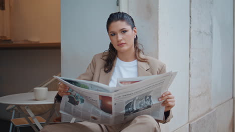 rich businesswoman reading newspaper at street cafeteria closeup. gorgeous woman