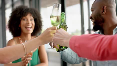 team of diverse happy colleagues toasting drinks together at office