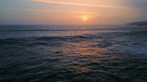 dramatic evening marine horizon with golden sunset light at cloudy sky aerial.