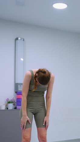 sesión de yoga en progreso con el director del gimnasio liderando, mostrando a los participantes en posturas coordinadas contra un telón de fondo de globos verdes y varios equipos de gimnasio