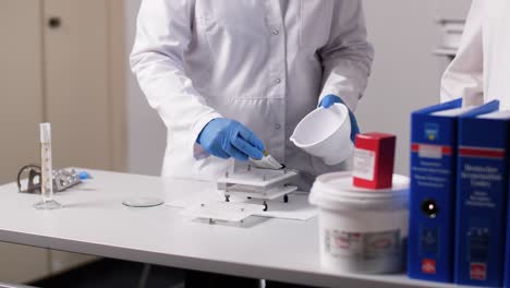 a pharmaceutical assistant works with a capsule machine