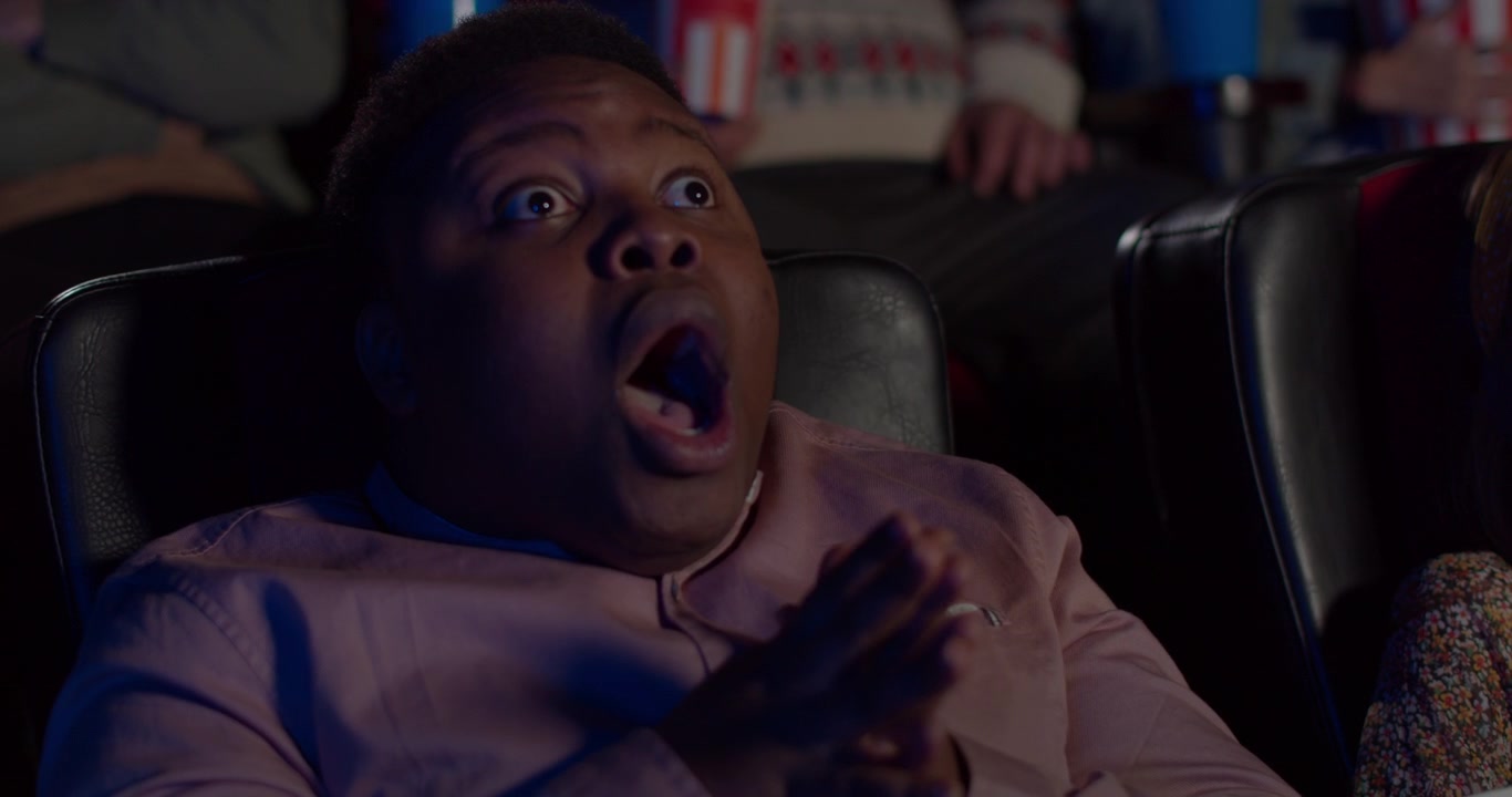 Young Man Watching an Intense Movie in a Cinema