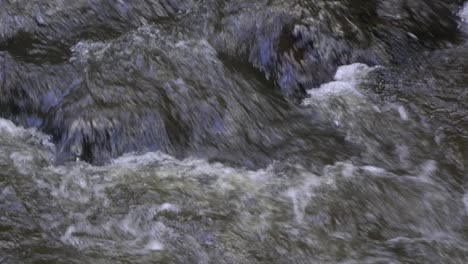 Cerca-De-La-Corriente-De-Agua-Turbia-Que-Fluye-Sobre-Las-Rocas