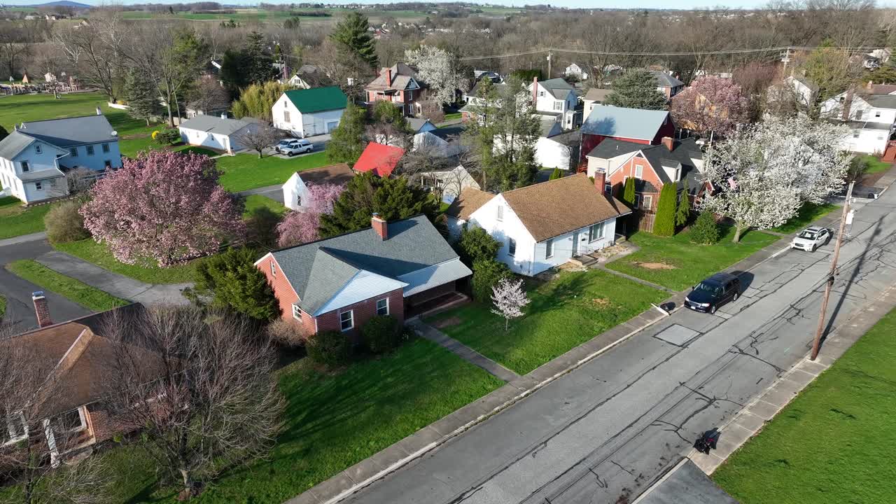 Aerial shot of a residential area with house, trees, vehicles in a sunny morning from the USA