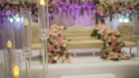 a shot beautifully captures the stage decorations, framing a stunning view of the candle decoration piece at a wedding event