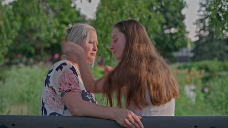 a strong heartfelt hug between a young woman and her mother in a peaceful park setting. pure love and connection, beautifully lit with natural light
