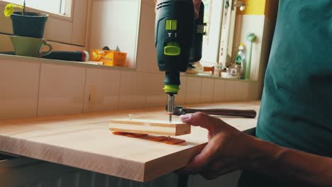 slow motion male carpenter drilling screw into horizontal