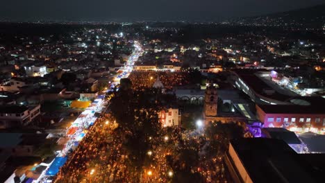 Dia-de-Muertos-celebration,-over-the-Illuminated-Mixquic-cementary-and-church-in-Mexico---aerial-view