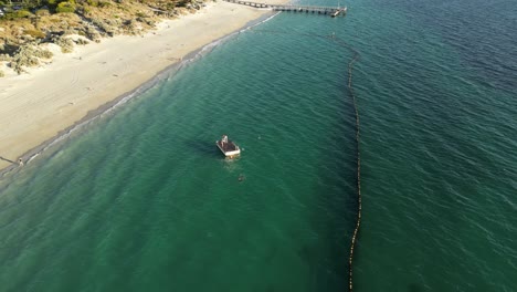 Aerial-orbiting-shot-of-kids-having-fun-in-ocean-protected-by-shark-net-at-Coogee-beach,Perth