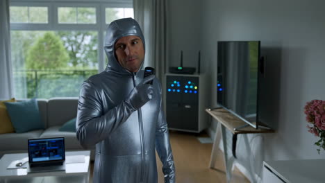 man in a silver suit measures electromagnetic fields in his home