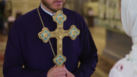 priest holding holy cross