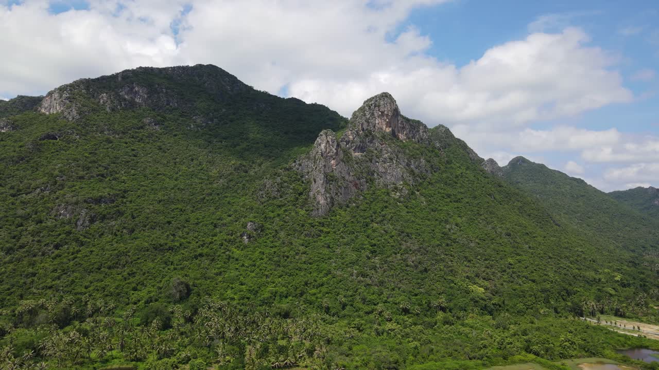 소금 팬과 코코넛 나무, 아름다운 푸른 하늘과 구름을 드러내는 이 석회암 산을 향한 공중 영상
