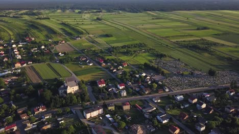 aerial view with tilt up of a little town in the countryside of poland during the sunset