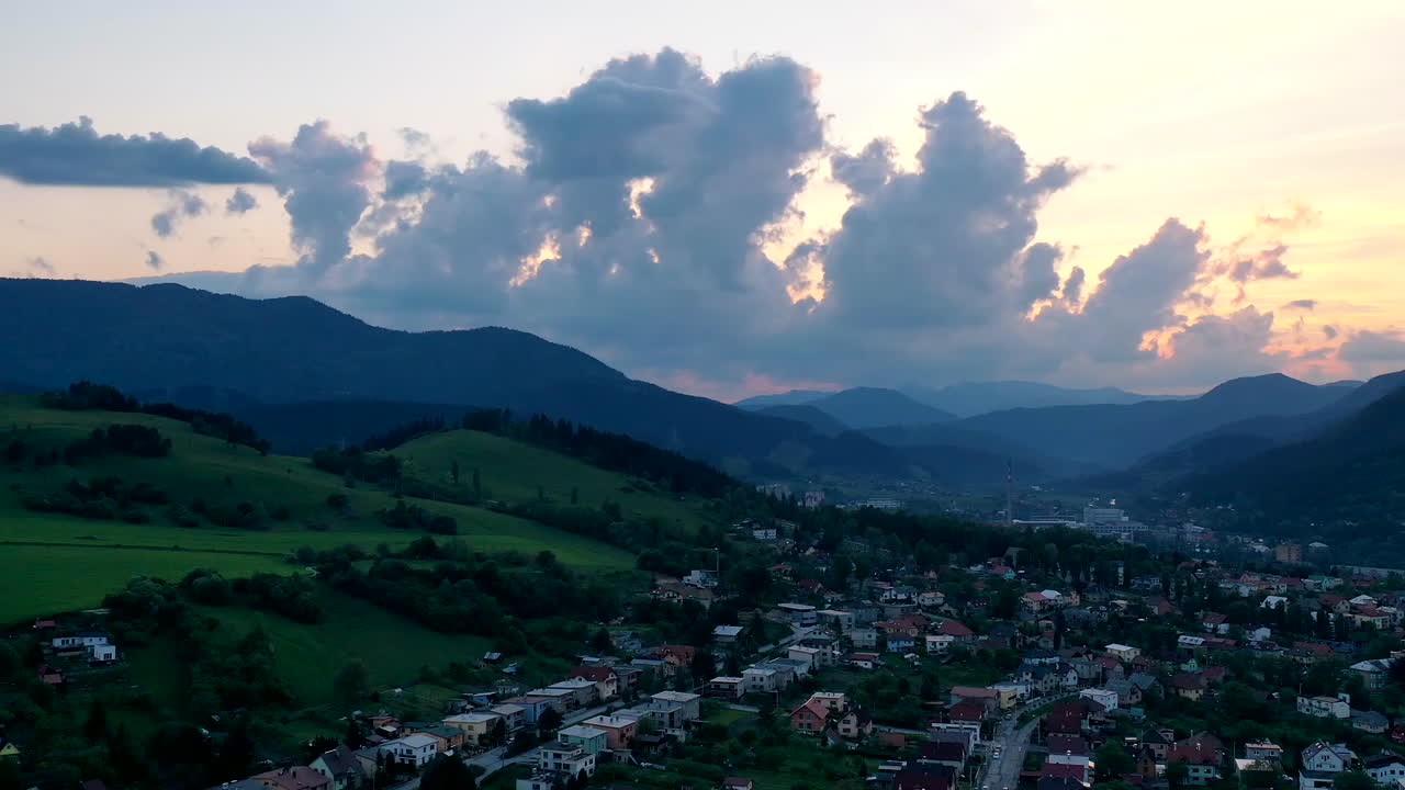 ružomberok, eslovaquia - una pequeña ciudad situada al pie de exuberantes colinas y montañas verdes con nubes onduladas en un fondo de cielo brillante - toma panorámica