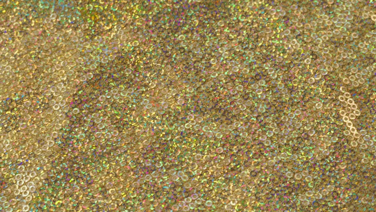 tela brillante brillante con pañuelos de primer plano. confeccionando ropa festiva. fondo brillante dorado. concepto de coser vestido de año nuevo