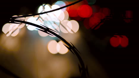 abstract traffic headlights on a busy freeway with barbed wire in the foreground-1