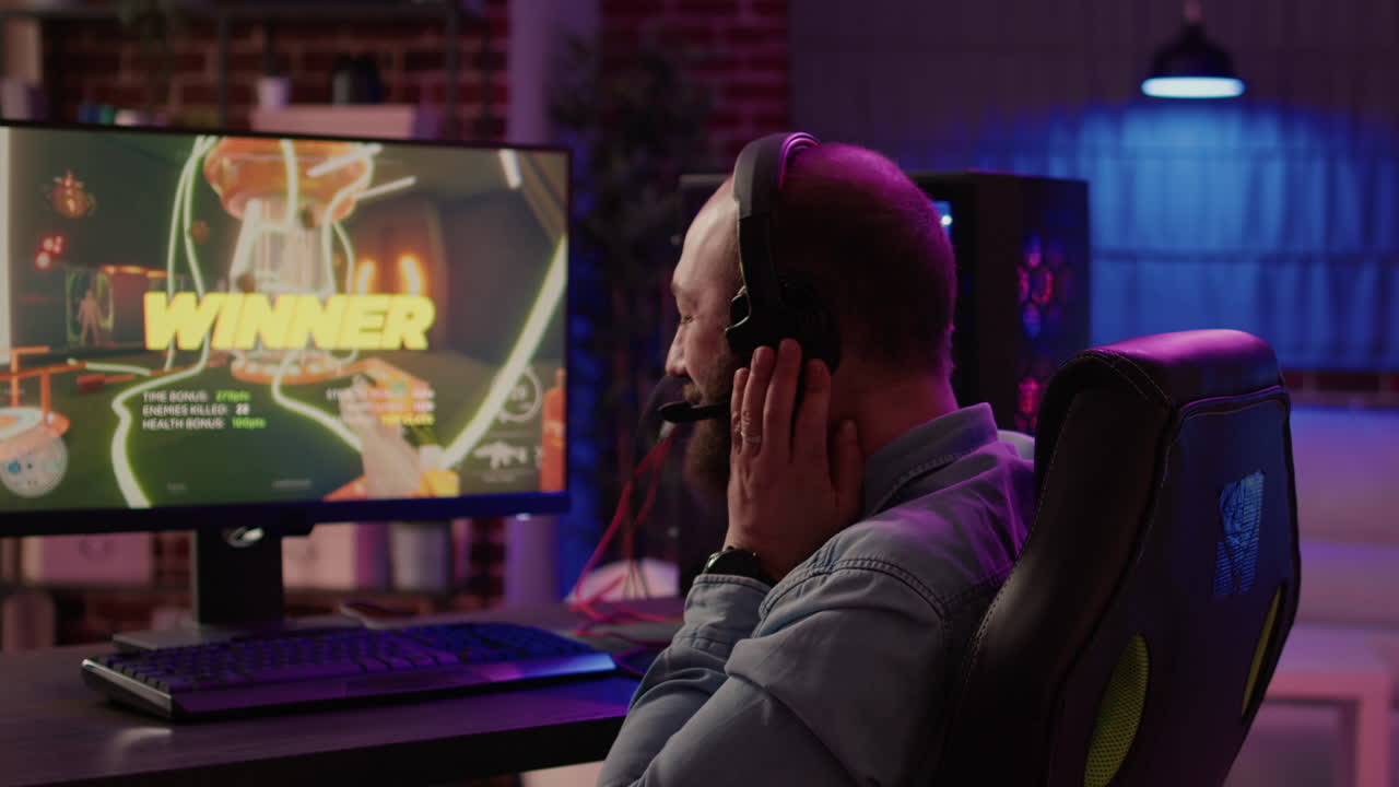 Un uomo che partecipa a un torneo online di sparatutto in prima persona si congratula con il team tramite cuffie dopo aver festeggiato la vittoria