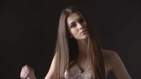 young woman in evening dress looking to camera and turning