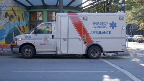 BC-Ambulance-Service-Ground-Transport-Parked-In-The-Street-Outside-Bridge-Housing-for-Women-Building-In-Vancouver-BC,-Canada