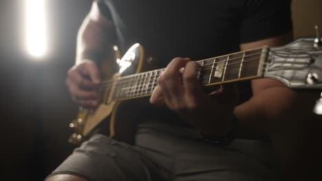 close up of guitar player picking on electric guitar