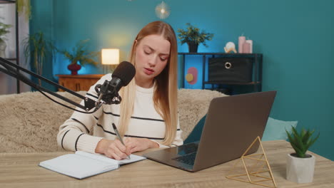 Caucasian young adult woman working on blog planning online stream at home sofa table inspiring