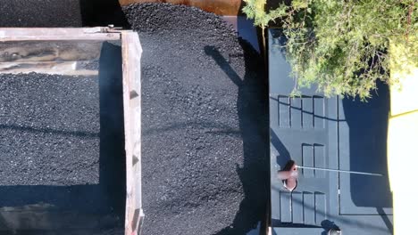 aerial shot 4k footage while truck pouring asphalt on asphalt machine