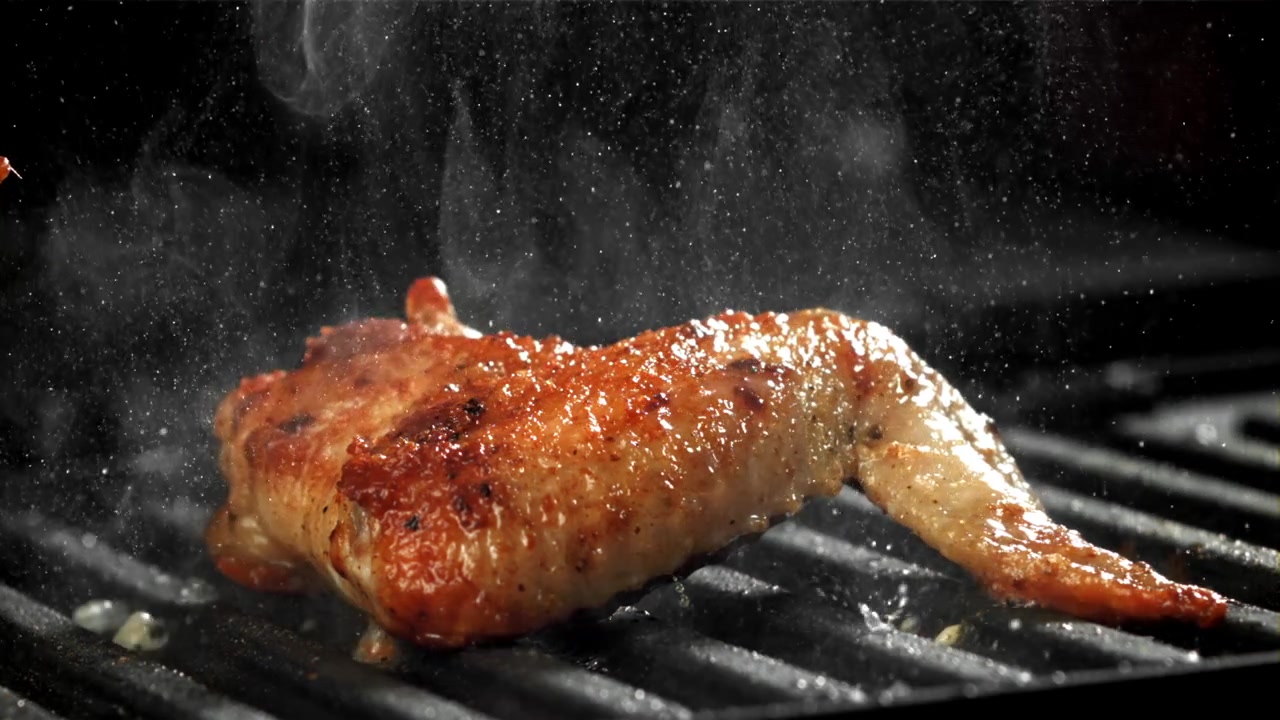 Aile de poulet dorée grésillant sur un grill chaud