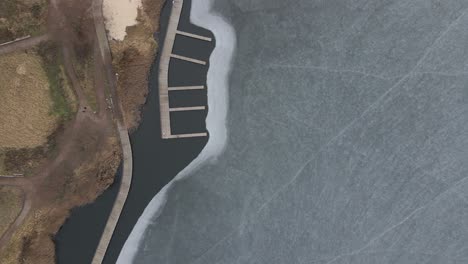 vuelo sobre lago congelado rompiendo hielo en pueblo rural, polonia