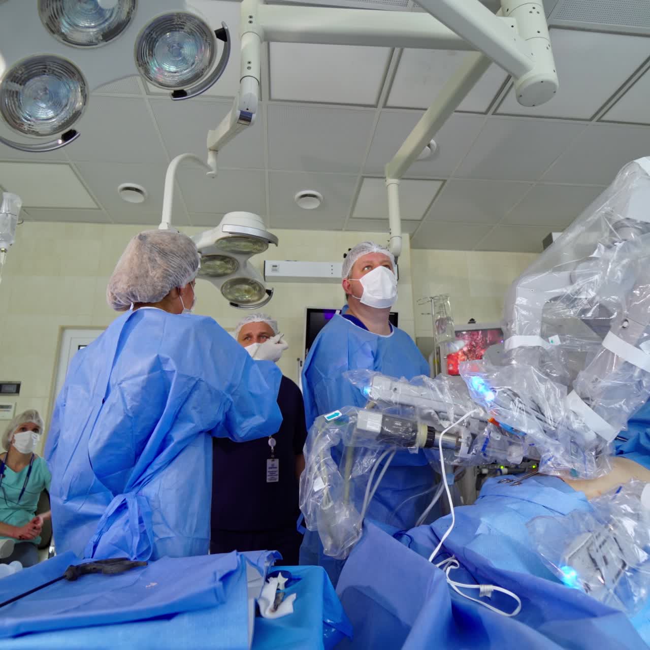 New technologies in medicine. Robotic surgery in modern clinic. Group of doctors in medical uniform near the medical robot performing microsurgery to a patient