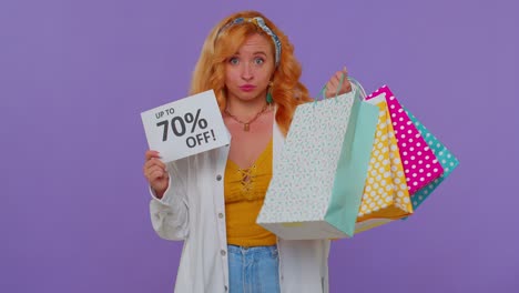 cheerful redhead girl showing shopping bags, up to 70 percent off inscriptions banner, black friday