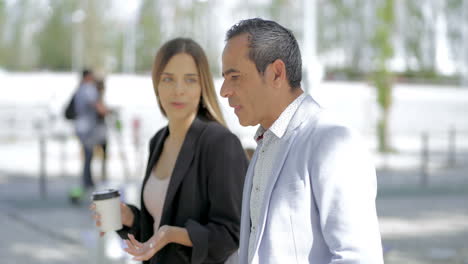 Male-and-female-colleagues-talking-outdoor