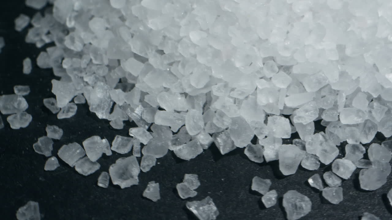 White salt close-up macro. Spice for food. Sea salt for bath. Man hand srewing salt on table . High quality 4k footage