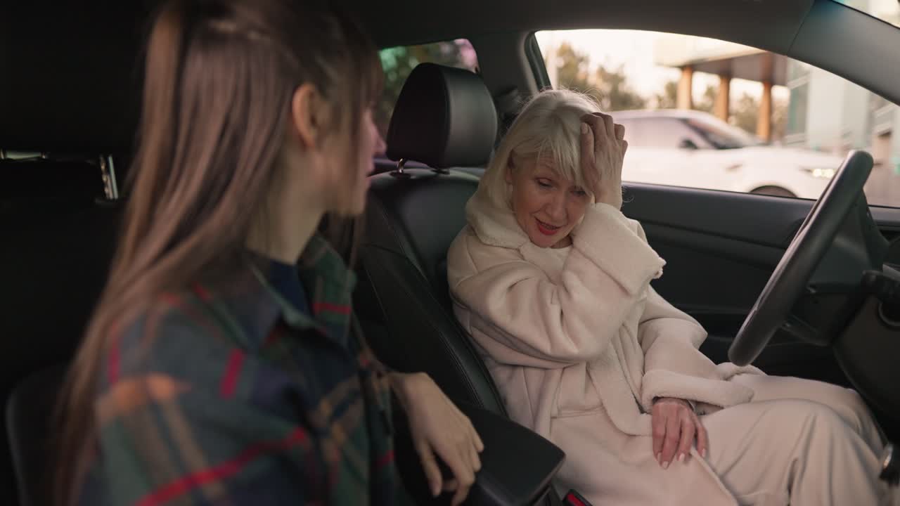 Two women having a conversation inside a car