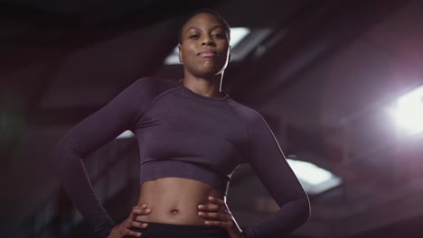 studio portrait of smiling woman wearing fitness clothing standing in gym