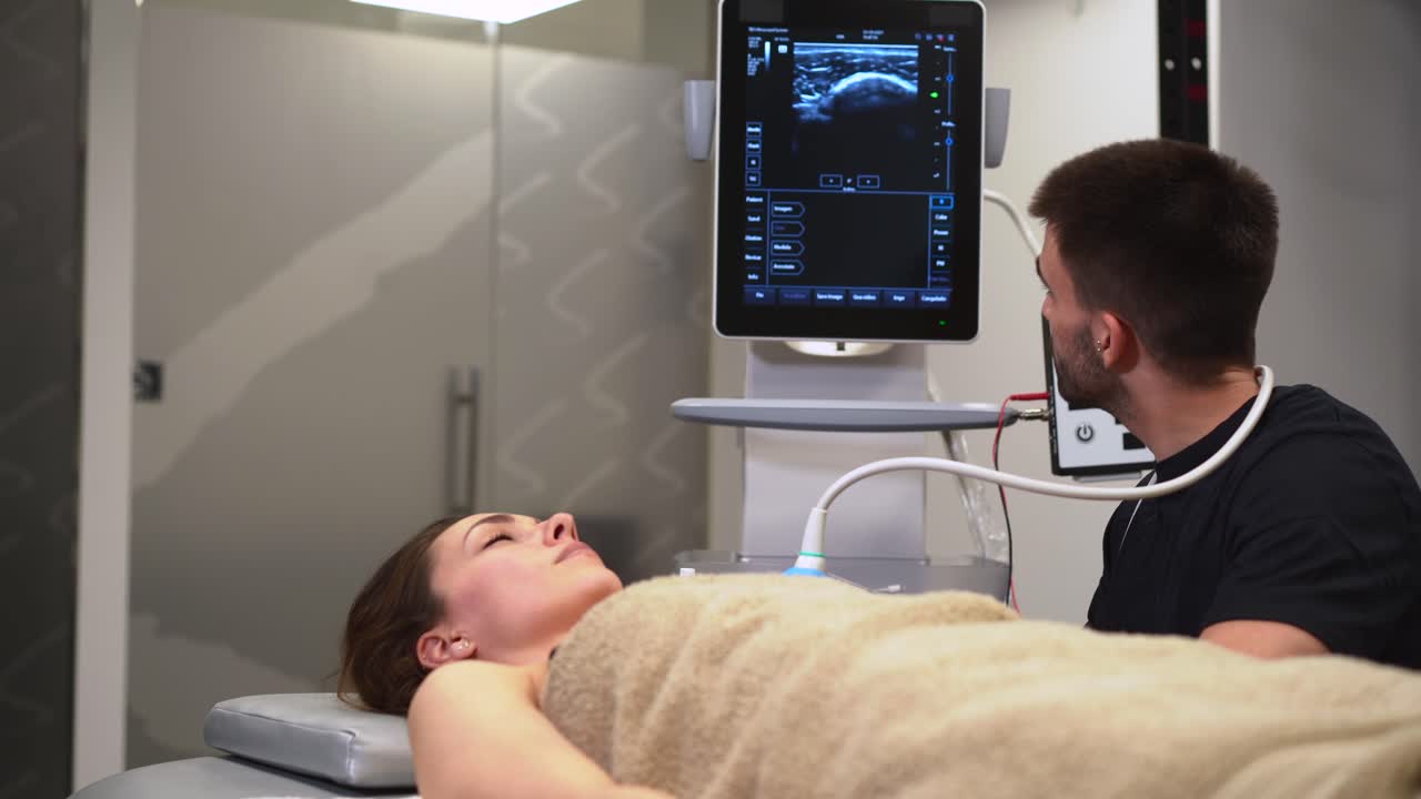 Physiotherapist with patient during ultrasonography examination in clinic