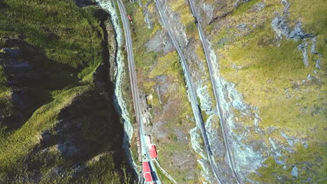 an aerial shot of a train going around the "nariz del diablo" or devil's nose in alausí, chimborazo province, ecuador