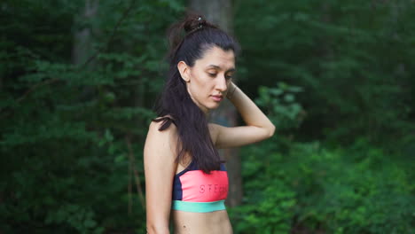 young woman in sport outfit taking a rest in the forest