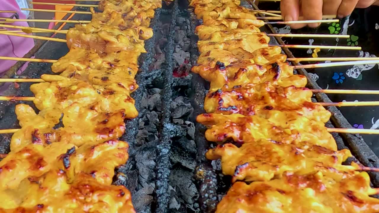 A detailed view of pork skewers being grilled over hot charcoal, showcasing the cooking process and smoky aroma.