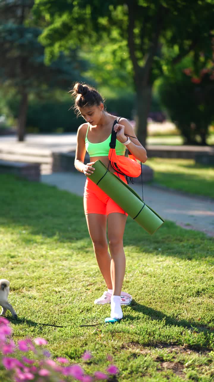 mujer practicando yoga en el parque con su perro