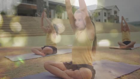 Animation-of-bokeh-lights-over-diverse-schoolgirls-doing-yoga-in-outdoor-class